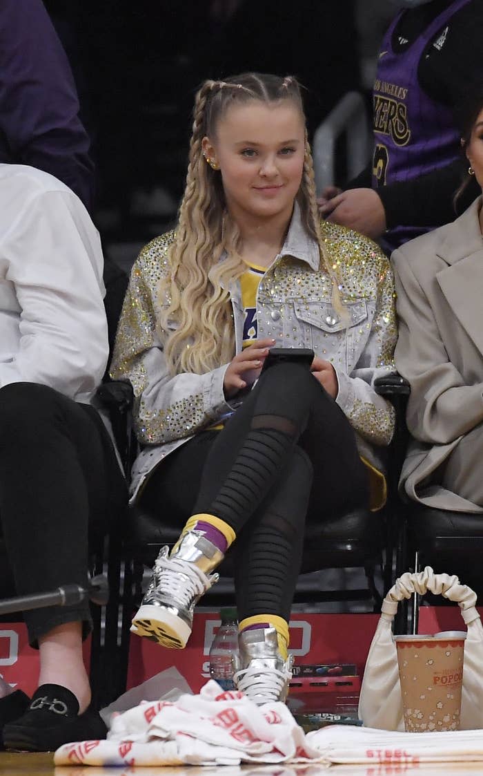 Siwa sits courtside at a basketball game