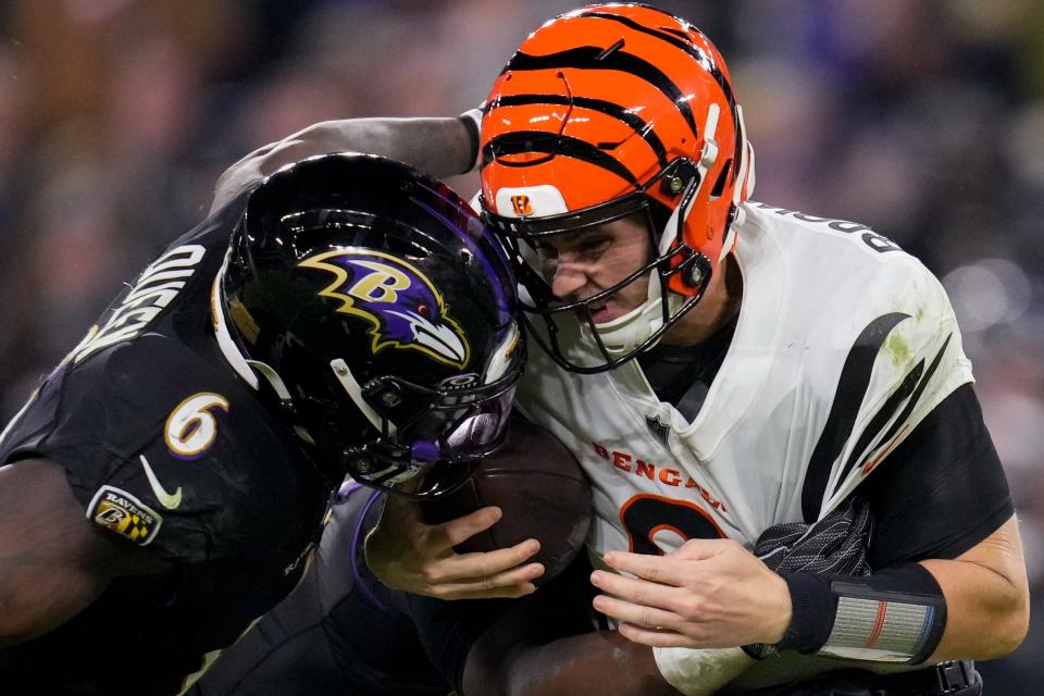 Cincinnati Bengals quarterback Jake Browning (6) is wrapped up and takes a hit from Baltimore Ravens linebacker Patrick Queen (6) as he scrambles in the fourth fourth quarter of the NFL Week 11 game between the Baltimore Ravens and the Cincinnati Bengals at M&T Bank Stadium in Baltimore on Thursday, Nov. 16, 2023. The Bengals fell to the Ravens, 34-20.