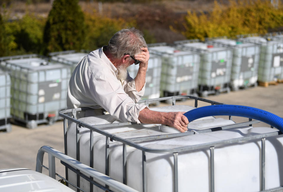 A local resident collects water handed out by charity group Granite Belt Water Relief in Stanthorpe, Queensland, Wednesday, October 9, 2019. Stanthorpe is the epicentre of state's drought crisis with the town expected to run out of water by the end of the year. (AAP Image/Dan Peled) NO ARCHIVING