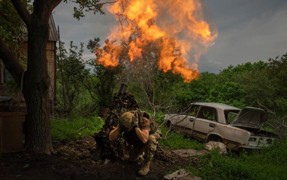 A Ukrainian soldier fires a mortar at Russians on the front line last month - AP