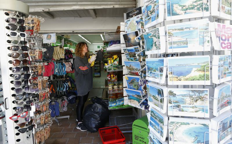 FILE PHOTO: Maria, the owner of a souvenirs and drinks shop prepares to reopen in Paguera beach