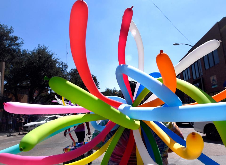 Multicolored balloons wave in the sunlight from where they were tied to the back of a participant in Saturday's Pride Parade on Cypress Street. The colors of the rainbow are a symbol of the LGBTQ+ community.