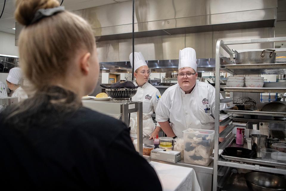 Kenneth Mitchell discusses a dish with a server during the AB Tech culinary arts capstone assignment April 27, 2023.
