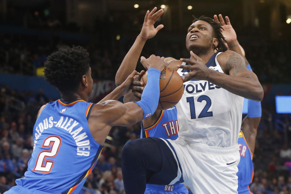 Minnesota Timberwolves guard Treveon Graham (12) has the ball stripped away by Oklahoma City Thunder guard Shai Gilgeous-Alexander (2) during the first half of an NBA basketball game Friday, Dec. 6, 2019, in Oklahoma City. (AP Photo/Sue Ogrocki)