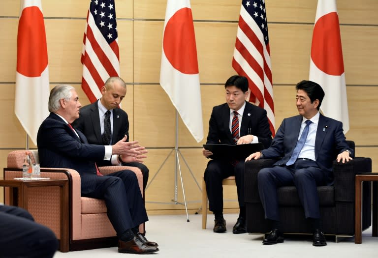 Rex Tillerson (L) speaks to Japanese Prime Minister Shinzo Abe: the US Secretary of State has vowed to press Beijing to rein in North Korea