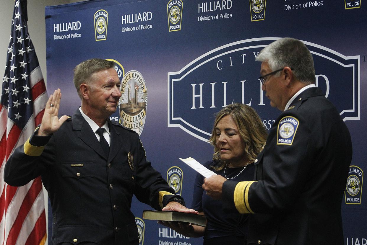 Lt. Ron Clark was sworn in as Hilliard Police Department's deputy chief by Chief Michael Woods as Clark's wife, Vicky, holds the Bible on July 5.