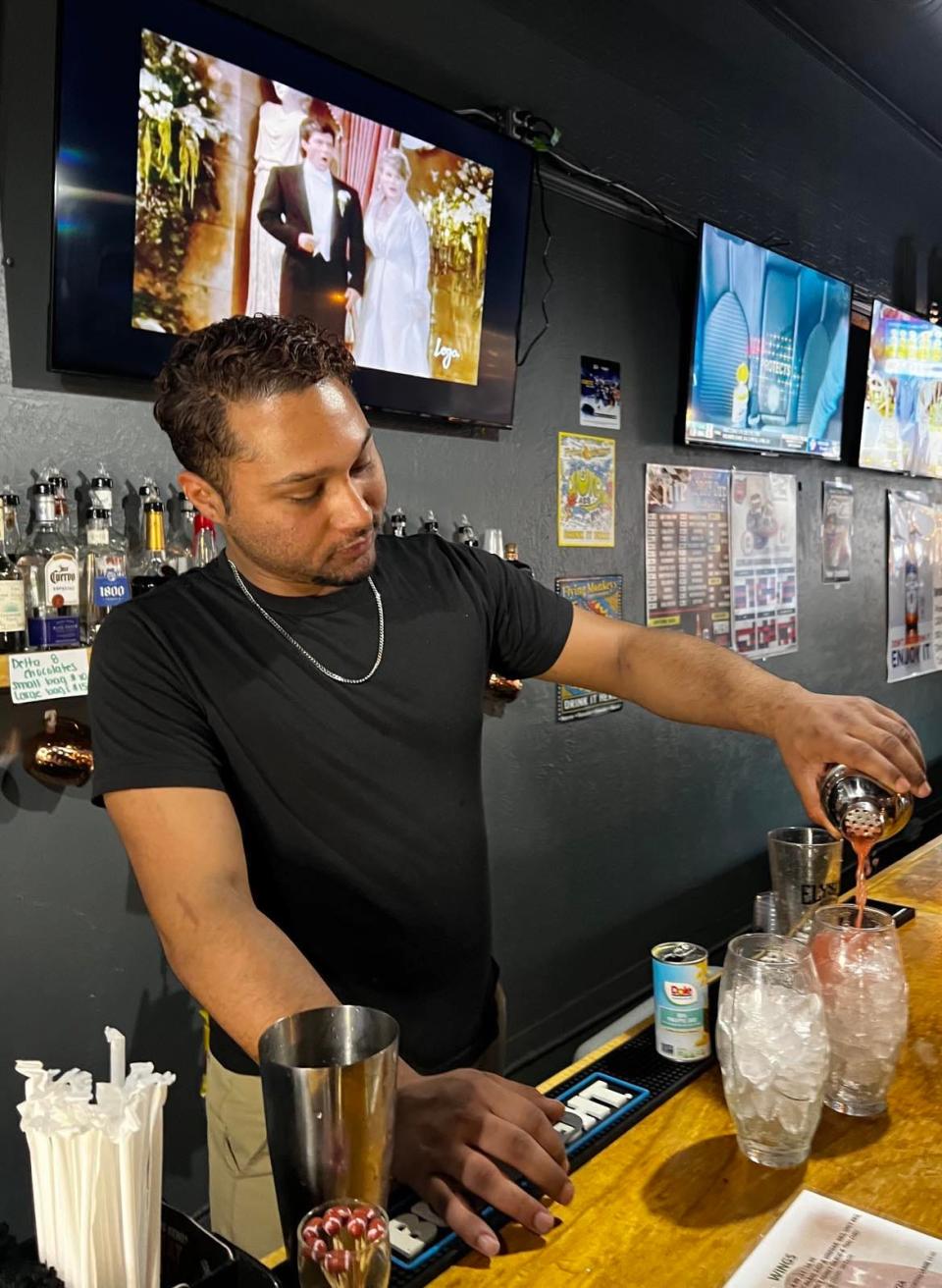 Jamal Gomez, of Gridiron Pizza & Sports Bar in downtown Canton, pours one of his specialty cocktails. Gomez has created new drinks for the eatery and hangout spot.