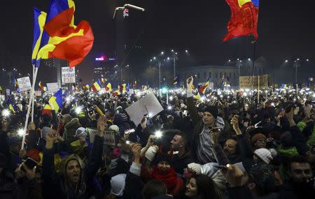 Protesters light their mobiles as they take part in a demonstration in Bucharest, Romania, February 5, 2017. REUTERS/Stoyan Nenov