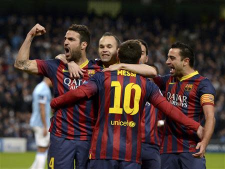 Barcelona players celebrate Lionel Messi's (BACK TO CAMERA) penalty against Manchester City during their Champions League round of 16 first leg soccer match at the Etihad Stadium in Manchester, northern England February 18, 2014. REUTERS/Nigel Roddis