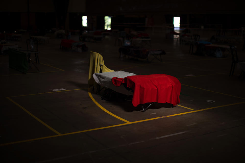 A bed is illuminated by a sun ray inside a sport center turned into temporary seasonal workers' shelter in Fraga, Huesca province, Spain, Thursday, July 2, 2020.Authorities in northeast Spain have ordered the lockdown of a county around the city of Lleida due to worrying outbreaks of the COVID-19 virus. Catalan regional authorities announced Saturday, July 4, 2020 that as of noon local time movement will be restricted to and from the county of El Segriá around Lleida which is home to over 200,000 people. Residents will have until 4 p.m. to enter the area. The new outbreaks are linked to agricultural workers in the rural area. (AP Photo/Emilio Morenatti)