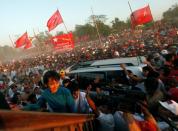 FILE PHOTO: Supporters wave their hands as Myanmar pro-democracy leader Aung San Suu Kyi arrives at Thone Khwa township