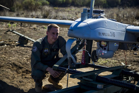 U.S. Marine Staff Sgt. James Smith inspects an RQ-7B Shadow unmanned aerial vehicle during preflight checks at the Pohakuloa Training Area, on the island of Hawaii, October 29, 2017. U.S. marine Corps Sgt. Ricky Gomez/Handout via REUTERS