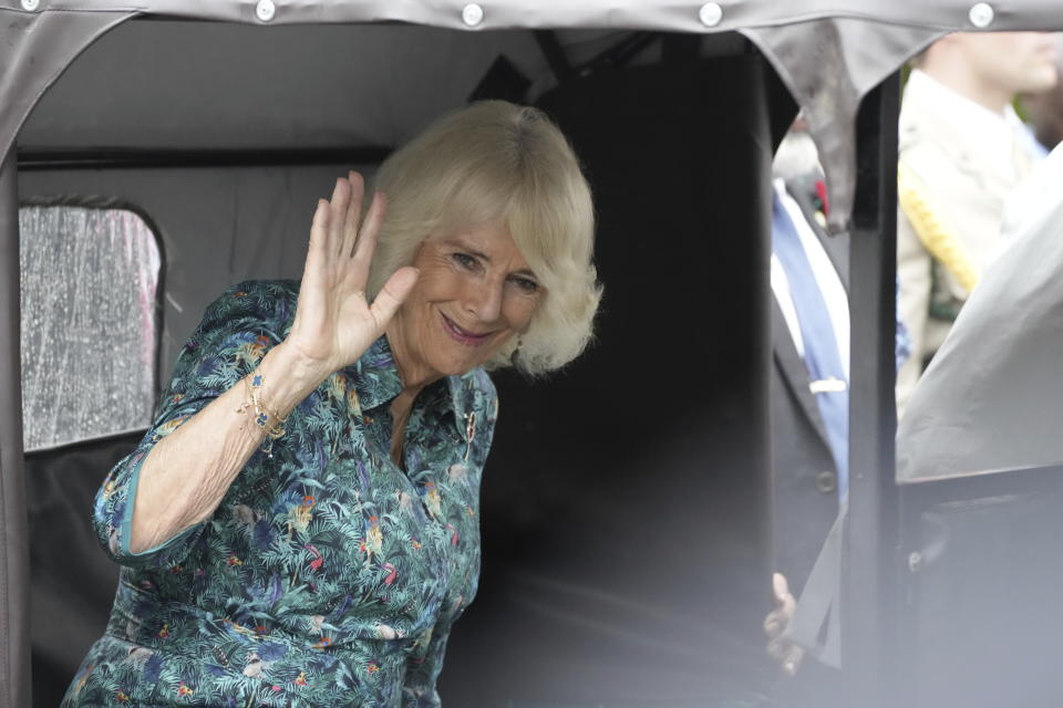 Britain's Queen Camilla waves to members of the public while seated on an auto rickshaw, locally known as tuk tuk, after visiting Fort Jesus, a UNESCO world heritage site in Mombasa, Kenya, Friday Nov. 3, 2023. (AP Photo/Brian Inganga)