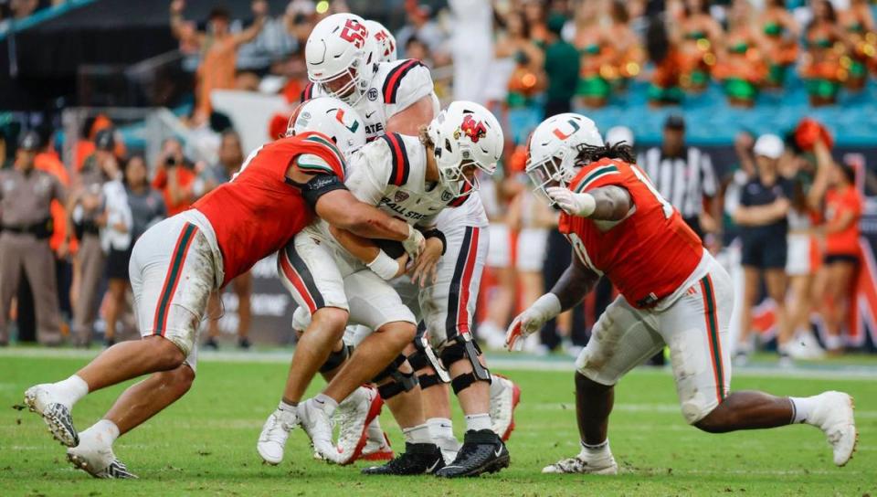 Miami Hurricanes defensive linemen Tyler Baron (9) and Simeon Barrow Jr. (10) sack Ball State Cardinals quarterback Kadin Semonza (3) in the first half of an NCAA football game at Hard Rock Stadium in Miami Gardens, Florida on Saturday, September 14, 2024.