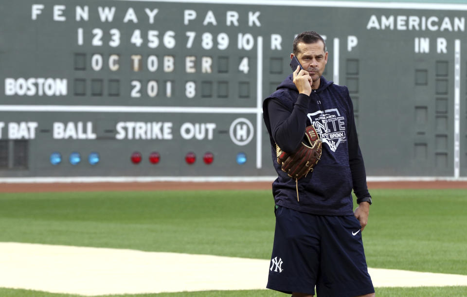 New York Yankees manager Aaron Boone talks on his phone at Fenway Park, Thursday, Oct. 4, 2018, in Boston. The Yankees are scheduled to face the Boston Red Sox in Game 1 of the AL Division Series on Friday. (AP Photo/Elise Amendola)