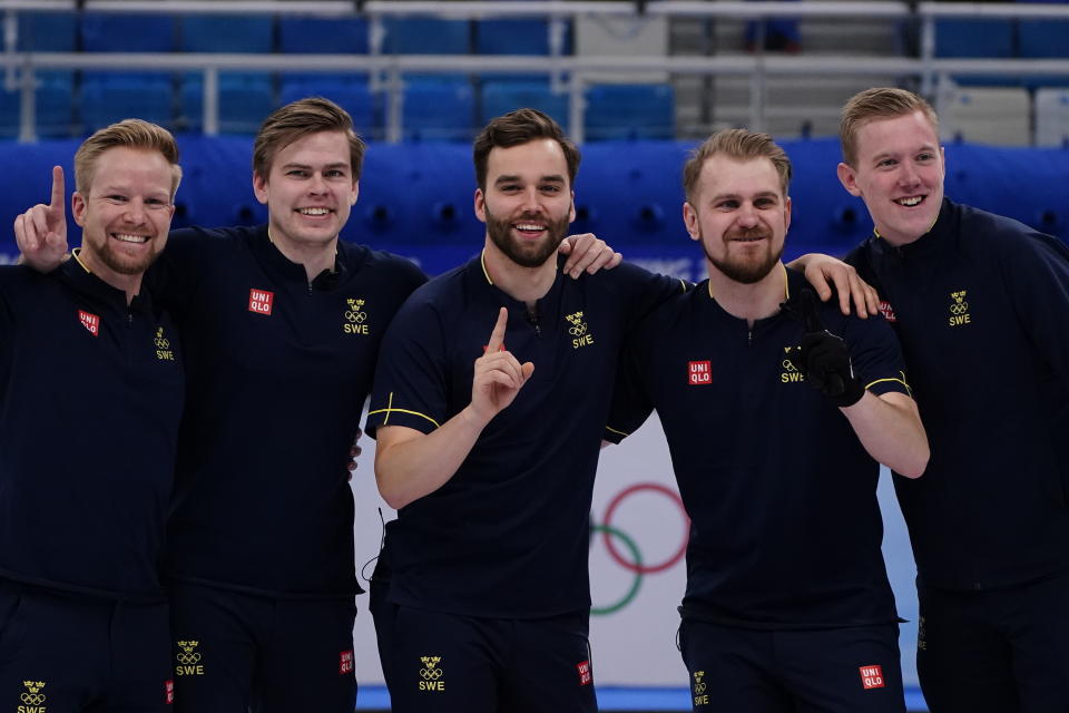 Team Sweden celebrates their win in the men's curling final match between Britain and Sweden at the Beijing Winter Olympics Saturday, Feb. 19, 2022, in Beijing. (AP Photo/Brynn Anderson)