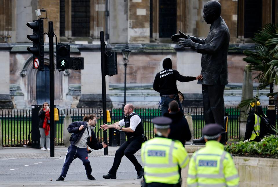 Police officers arrest a protestor during an anti-COVID-19 lockdown demonstration outside the Houses of Parliament in Westminster, central London on January 6, 2021. - Britain toughened its coronavirus restrictions on Tuesday, with England and Scotland going into lockdown and shutting schools, as surging cases have added to fears of a new virus variant. (Photo by Tolga Akmen / AFP) (Photo by TOLGA AKMEN/AFP via Getty Images)