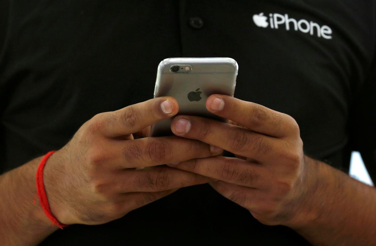 FILE PHOTO: A salesman uses his iPhone at a mobile phone store in New Delhi, India, July 27, 2016. REUTERS/Adnan Abidi/File Photo