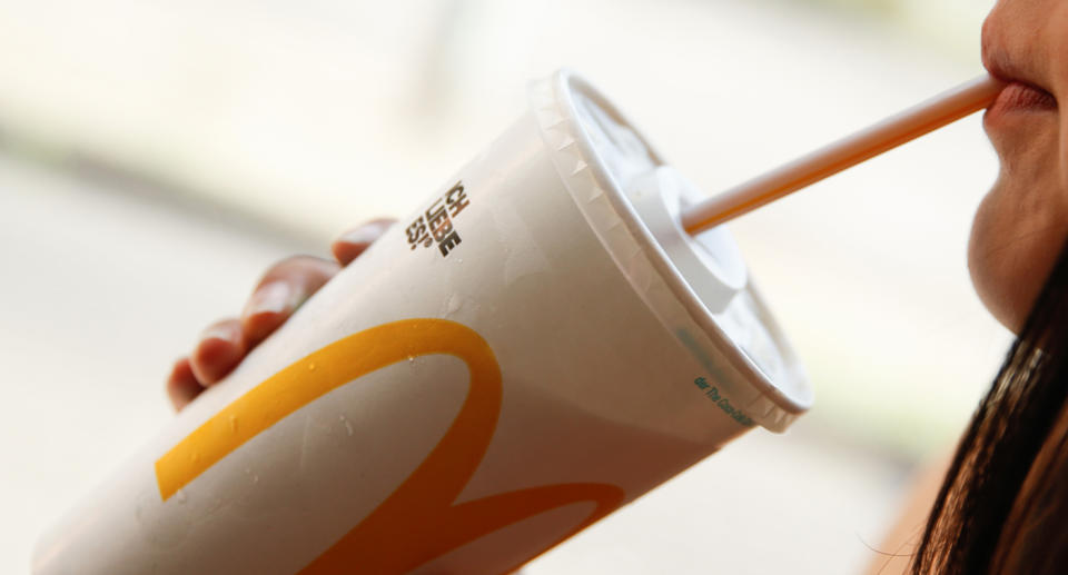 Woman drinking drink from McDonald's.