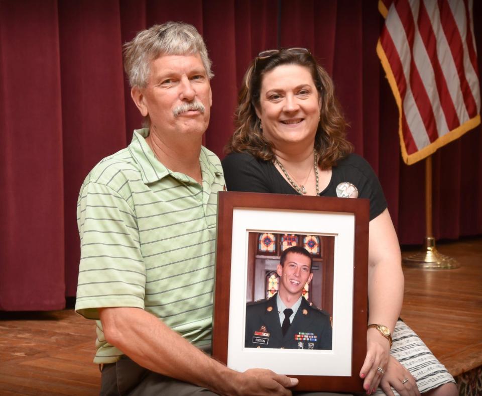 John and Lynn Patton hold a photo of their son Matthew in 2016.