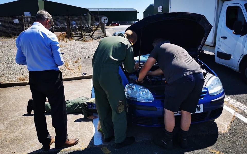 Royal Navy personnel tried to locate Fergie the kitten hidden in the engine space of a car at RNAS Culdrose in Cornwall - Martyn Collick/Cats Protection