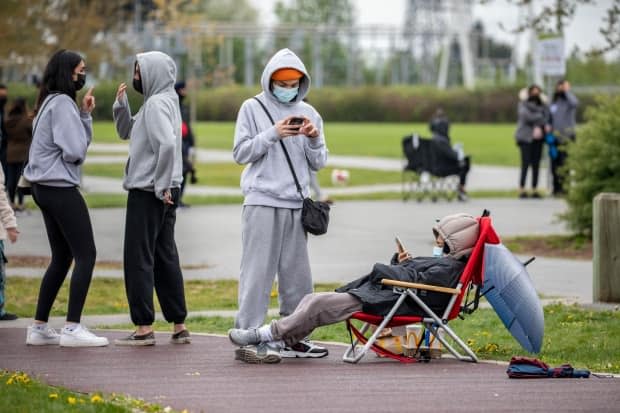 Hundreds of people wait in a line at a vaccine pop-up clinic at Newton Athletic Park in Surrey, B.C., on April 27, 2021.  (Ben Nelms/CBC - image credit)