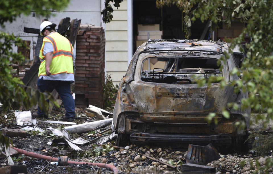A car was destroyed from a house explosion on Tuesday as officials investigate the scene Wednesday, June 5, 2024, in the Chicago suburb of Lake Zurich, Ill. First responders found the home leveled after the explosion about 8:30 p.m. Tuesday, according to the Lake County sheriff's office. (Paul Valade/Daily Herald via AP)