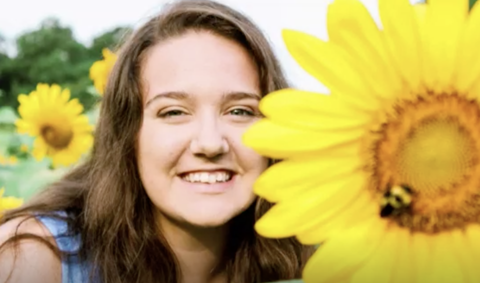 Jeanna Triplicata, 18, is pictured with a sunflower.