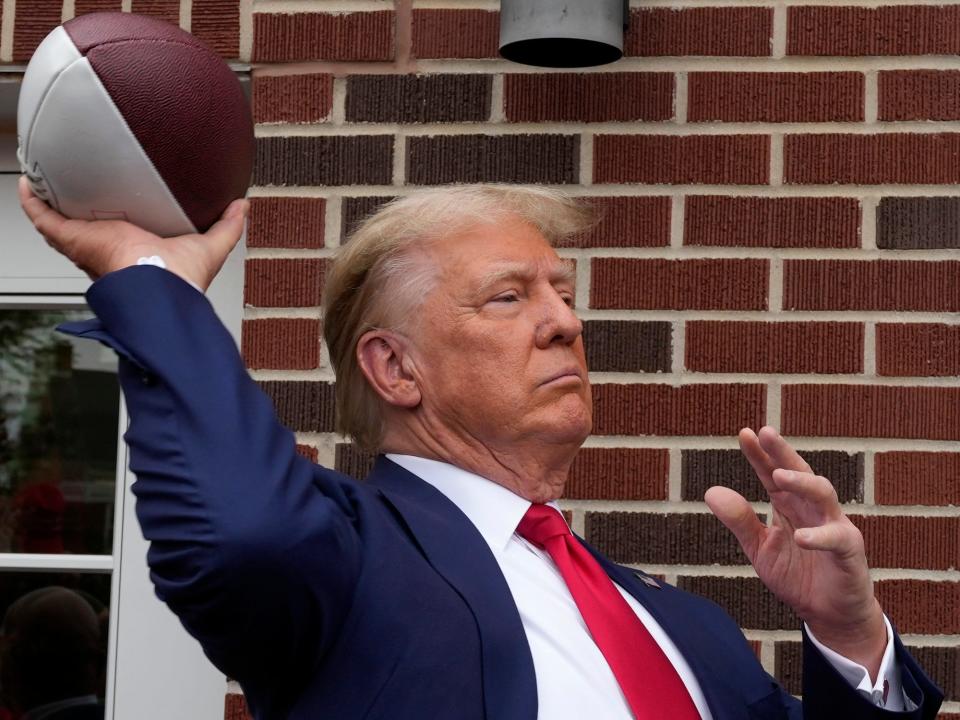 Former President Donald Trump throws a football to the crowd during a visit to the Alpha Gamma Rho, agricultural fraternity, at Iowa State University before an NCAA college football game between Iowa State and Iowa, Saturday, Sept. 9, 2023, in Ames, Iowa.
