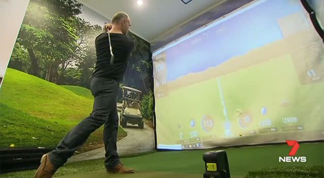 Proud man cave owner Laurie plays the virtual golf course. Source: 7 News