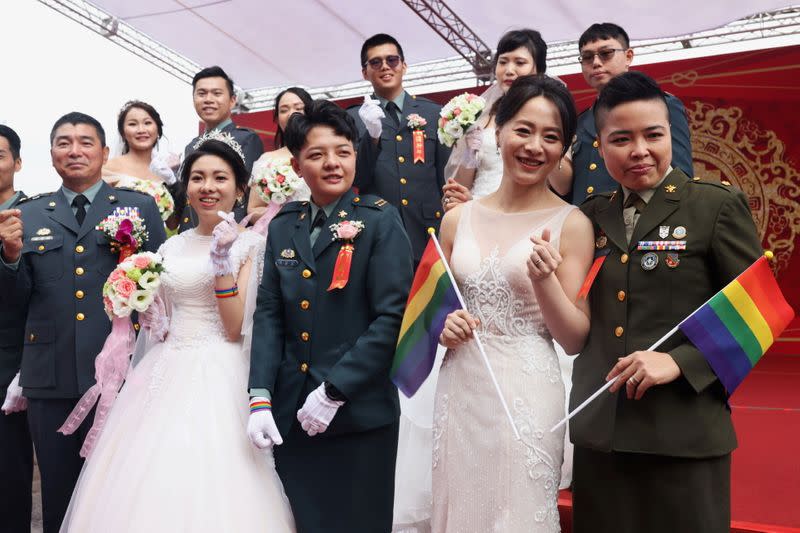 Two same-sex couples take a group photo during a military mass wedding in Taoyuan