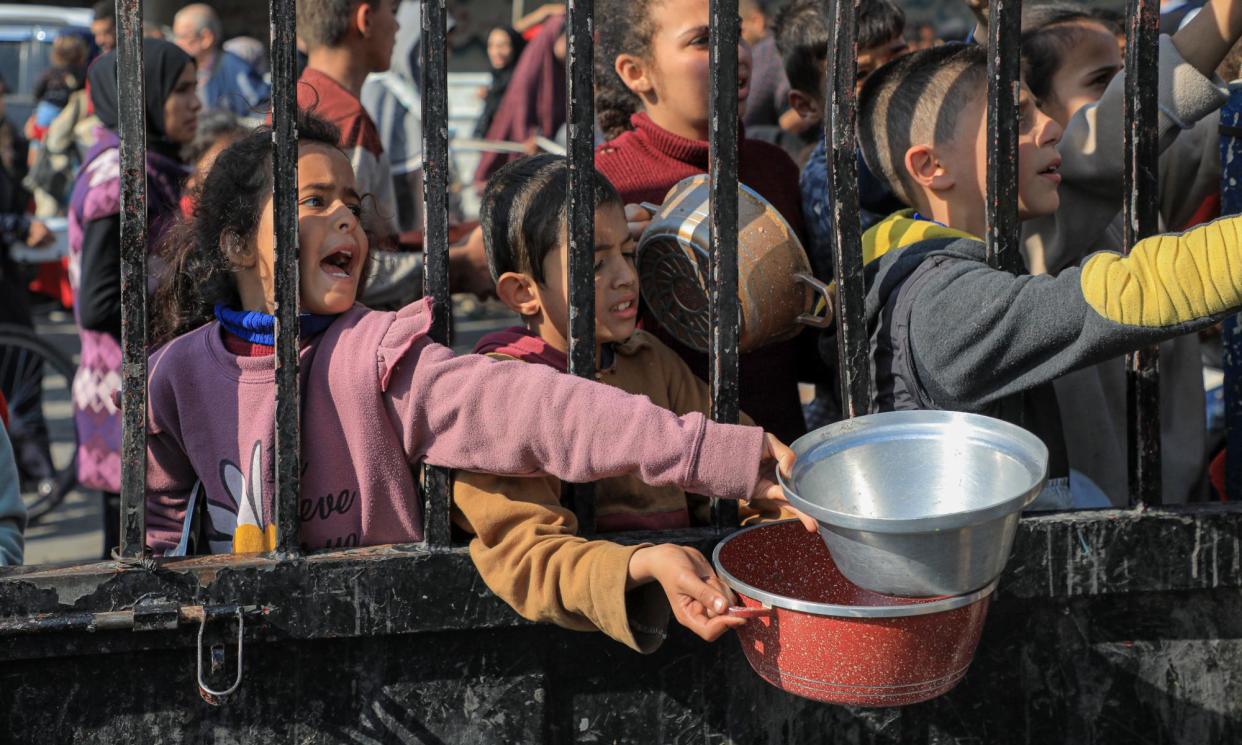 <span>Children queue up in Rafah for aid.</span><span>Photograph: Xinhua/Rex/Shutterstock</span>