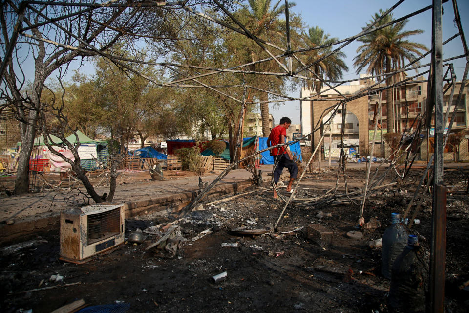 A protester inspects burned tents near Tahrir Square, Baghdad, Iraq, Monday, July, 27, 2020. Fresh violence erupted between demonstrators and Iraqi security forces in central Baghdad, human rights monitors and Iraqi security and health officials said on Monday, following months of quiet in the wake of the coronavirus pandemic. (AP Photo/Khalid Mohammed)