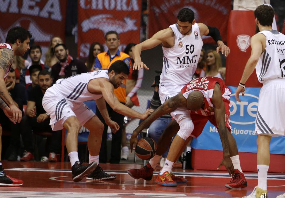Olympiakos' Cedric Collins, right, fights for the ball with Real Madrid's Felipe Reyes, left, and Salah Mejri during a Euroleague playoff game 3 basketball match at the Peace and Friendship Arena in Athens' port of Piraeus on Monday April 21, 2014. (AP Photo/Thanassis Stavrakis)
