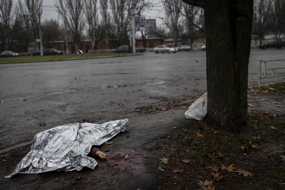 The body of a woman killed during a Russian attack lies under an emergency blanket before being transported to a morgue in Kherson, southern Ukraine, Friday, Nov. 25, 2022. (AP Photo/Bernat Armangue)