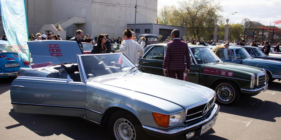 People examine a retro Mercedes car parked near the Gorky Park in Moscow in April 2023.