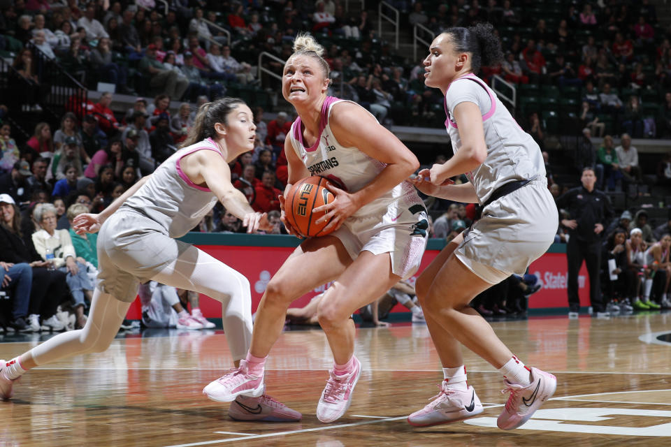 Michigan State guard Theryn Hallock, center, drives against Ohio State guards Emma Shumate, left, and Celeste Taylor during the second half of an NCAA college basketball game, Sunday, Feb. 11, 2024, in East Lansing, Mich. Ohio State won 86-71. (AP Photo/Al Goldis)