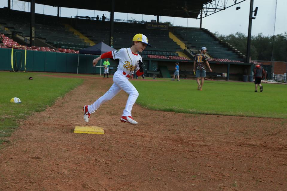 A camper rounds first during the Savannah Bananas winter baseball camp Tuesday at Grayson Stadium.