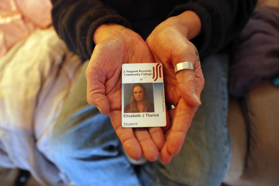 Kim Mincks shows an identification card of her housemate Elizabeth Theriot reacts inside her home in Gonzalez, La., Sunday, Jan. 27, 2019, where Elizabeth and her husband Keith Theriot, were killed in another room yesterday while Mincks slept. (AP Photo/Gerald Herbert)