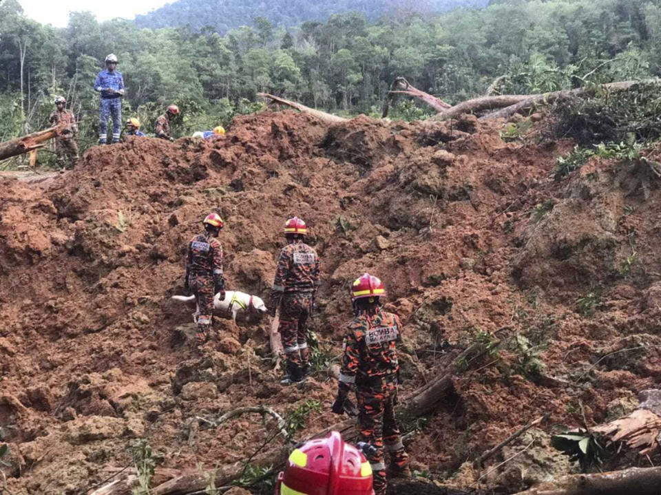 In this photo released by Korporat JBPM, rescuers work at a campsite following a landslide, in Batang Kali, Selangor state, on the outskirts of Kuala Lumpur, Malaysia, Dec. 16, 2022. A landslide Friday at a tourist campground in Malaysia left more than a dozen of people dead and authorities said a dozen others were feared buried at the site on an organic farm outside the capital of Kuala Lumpur. (Korporat JBPM via AP)