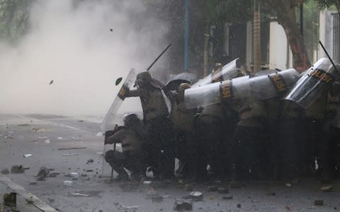 Indonesian riot police clash with protesters in Medan, northern Sumatra - Credit: Antara Foto/Reuters