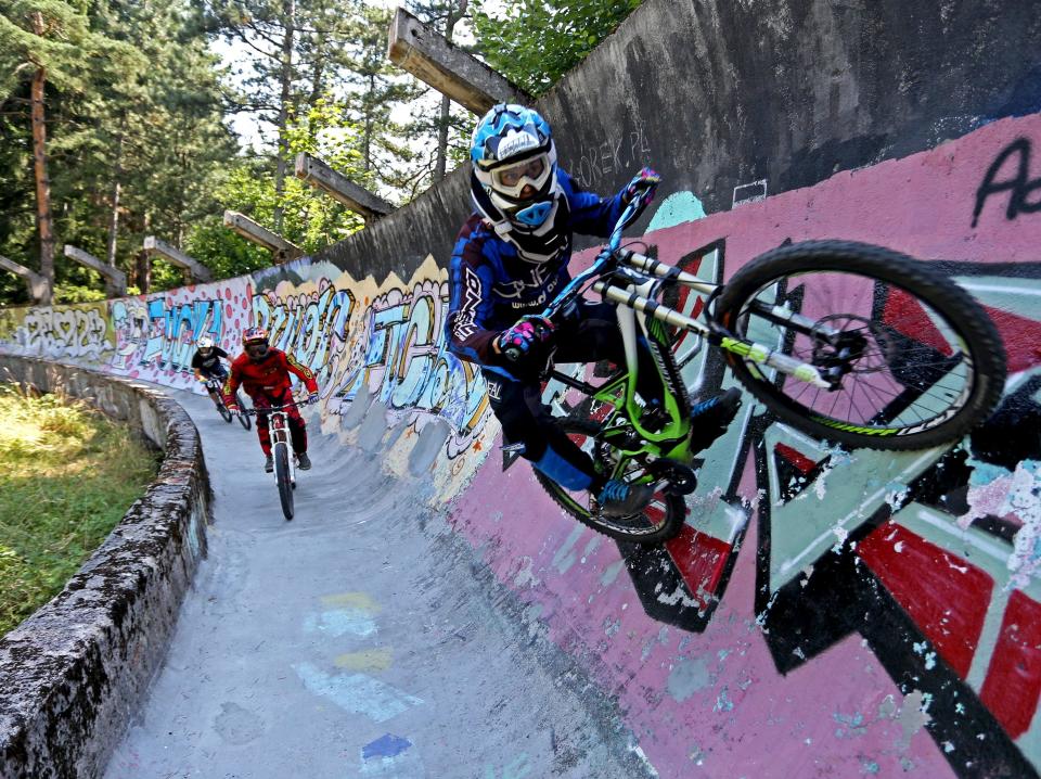 Downhill bikers Mulic, Hadzic and Kolar train on the disused bobsled track from the 1984 Sarajevo Winter Olympics on Trebevic mountain near Sarajevo