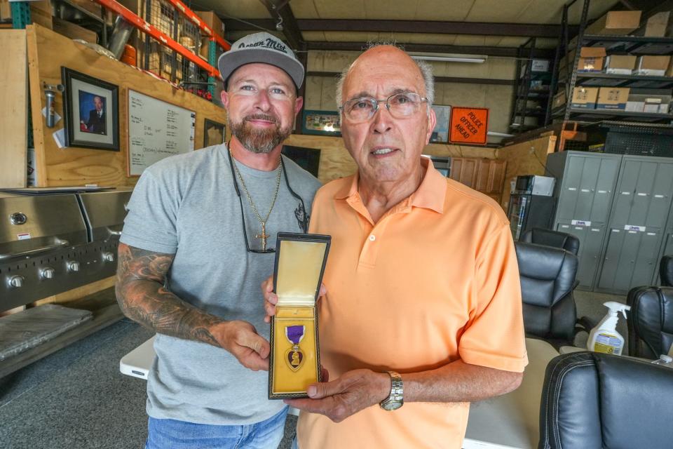 Last Friday, David Arone, right, a nephew of Joseph J. Costa, World War II medic and posthumous Purple Heart recipient, met Jim Martel at his shop, Martel Plumbing and Heating in Lincoln, where Martel returned the Purple Heart he found in a house he bought on Crane Street in Pawtucket.