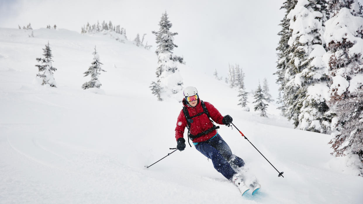  A skier in a red jacket in the backcountry. 