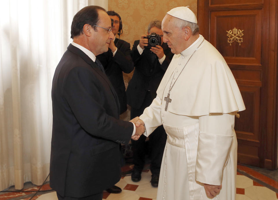 French President Francois Hollande, left, is welcomed bY Pope Francis on the occasion of their private audience at the Vatican, Friday, Jan. 24, 2014. Hollande met Friday with Pope Francis amid tensions in his private life over a gossip magazine's report about an alleged affair with an actress. (AP Photo/Alessandro Bianchi, Pool)