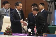 China's Foreign Minister Wang Yi (L) shakes hands with North Korea's Foreign Minister Ri Su Yong (R) during the launching ceremony for the logo of the ASEAN Regional Forum Disaster Relief Exercise (ARF DiREx) 2015, at the Myanmar International Convention Center (MICC) in Naypyidaw, August 10, 2014. REUTERS/Nicolas Asfouri/Pool