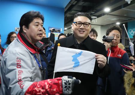 Ice Hockey – Pyeongchang 2018 Winter Olympics – Women Preliminary Round Match - Korea v Japan - Kwandong Hockey Centre, Gangneung, South Korea – February 14, 2018 - Kim Jong-un impersonator holds a Korean unification flag. REUTERS/Lucy Nicholson