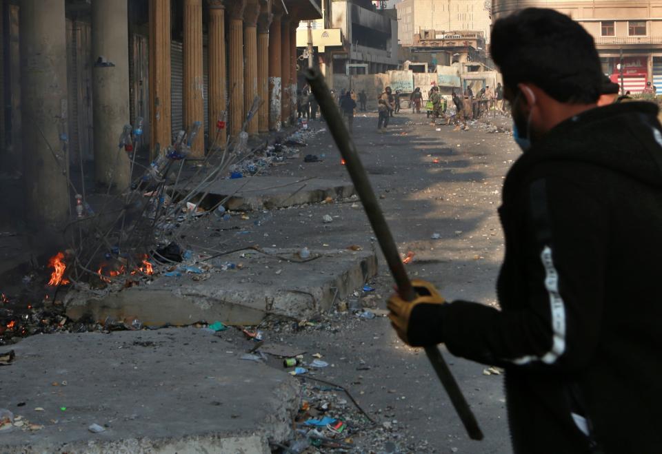 Riot police retreat while anti-government protesters use Molotov cocktails during clashes on Rasheed Street, Baghdad, Iraq, Tuesday, Nov. 26, 2019. (AP Photo/Khalid Mohammed)