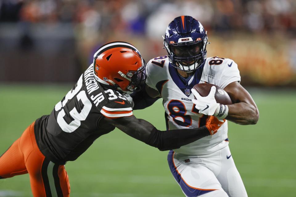 Denver Broncos tight end Noah Fant plays against Cleveland Browns defensive back Ronnie Harrison.