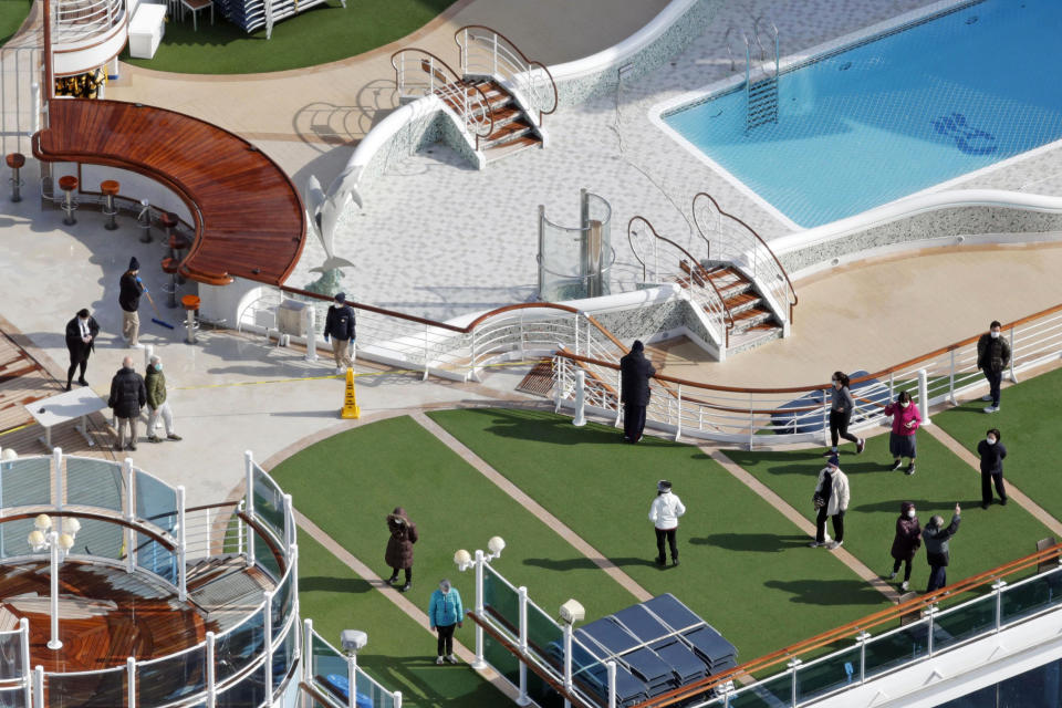 Masked passengers are seen on the deck of the cruise ship Diamond Princess docked at Yokohama Port, near Tokyo, Friday, Feb. 7, 2020. Japan on Friday reported 41 new cases of a virus on the cruise ship that's been quarantined. About 3,700 people have been confined aboard the ship. (Sadayuki Goto/Kyodo News via AP)